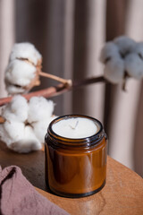 Soy wax hand made candle on wooden table and cotton branch, mockup design
