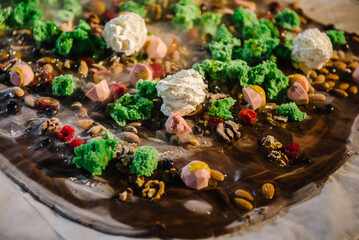 Hand made chocolate with nuts, almond, walnut, cream, candies, jelly and decor. Cooled liquid nitrogen on hot chocolate. Chocolatier сooking, cooling melted mass. Closeup