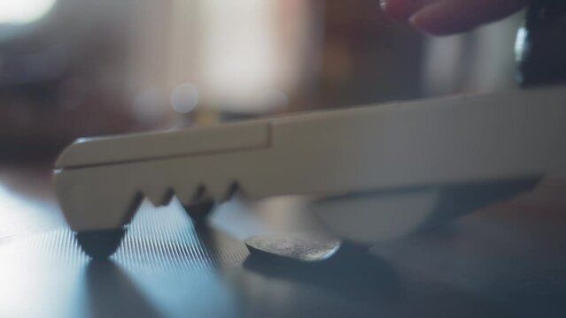 Chef slicing cooked beets on a mandoline slicer. Slow motion, shallow depth of field.  
