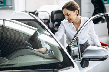 Woman choosing a car in a car showroom