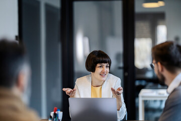 A junior executive is having briefing with colleagues at the boardroom.
