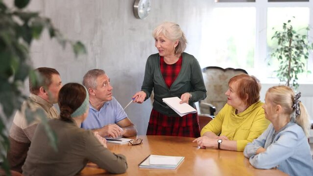 Communication of elderly at the round table. Training and group therapy with a psychologist. High quality 4k footage Generative AI