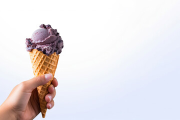 Hand holding delicious blueberry ice cream in a crispy waffle cone with copy space. Created with Generative AI Technology