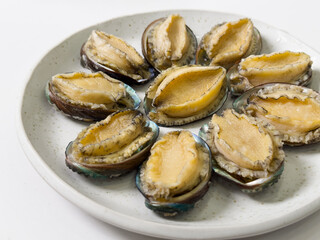 Delicious raw abalone in a plate on white table background.