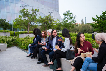 Group of workers from the financial sector taking a break to eat in a business district. Concept:...