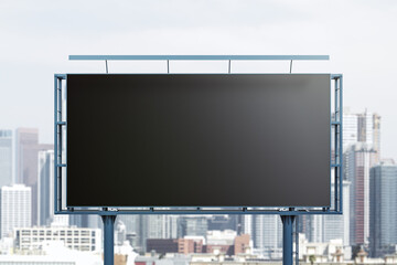 Blank black billboard on city buildings background, front view. Mockup, advertising concept