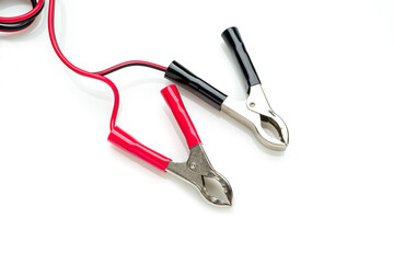 Red and black clip-on connecting and charging cable for 12 Volt battery isolated on white background
