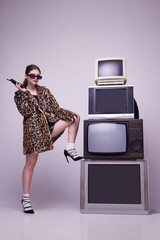 Television creative manager. Young girl in stylish animal print coat and sunglasses posing near...