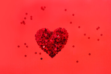 Round glitter red sequin in heart shape isolated on red background - love and valentine concept.