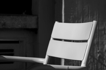 Black and white image of chair backrest with sunlight and cement concrete background, Outdoor...