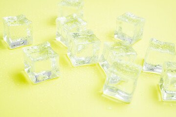 Ice cubes with water drops scattered on background, top view.