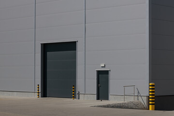 Grey roller shutter entrance for industrial building's loading area.