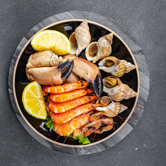 fresh seafood plate snack shrimp, crab claw, clam, rapan, trumpeter mollusk  meal food on the table copy space food background rustic top view