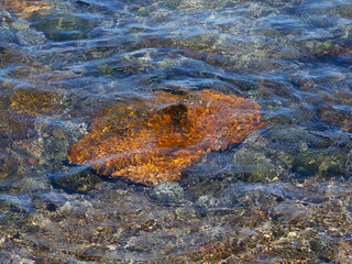 Photo of transparent water with stones in the background