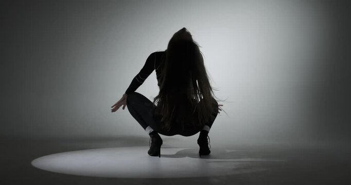 Beautiful woman in black dress dancing sensual sexy dance on the floor in spotlight Generative AI