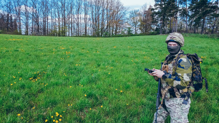 Modern army soldiers using aerial drone for artillery guidance and scouting view enemy positions in...