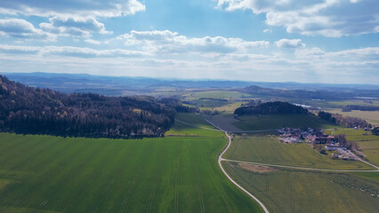 Green field, farmland with picturesque European landscape. Road in the middle of fields. Soft light. footage video drone view. in the background a range of mountains
