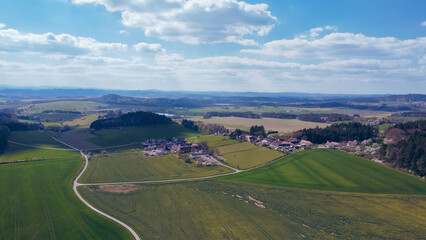 Fototapeta na wymiar Green field, farmland with picturesque European landscape. Road in the middle of fields. Soft light. footage video drone view. in the background a range of mountains