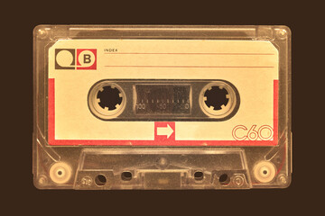 Vintage old audio compact cassette in front of a dark brown background