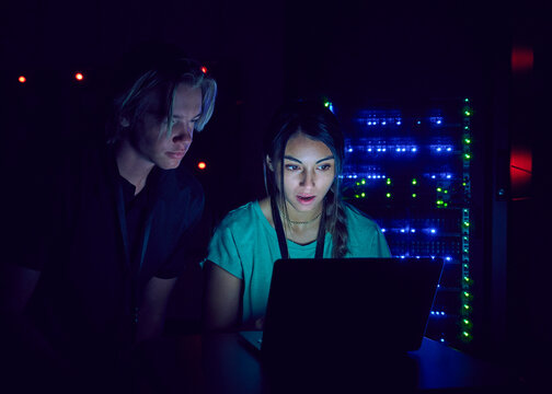 Technicians using laptop in server room