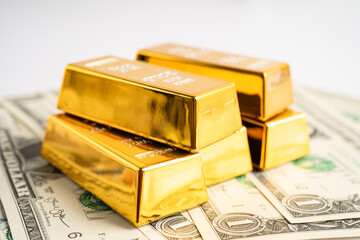 Gold bar on US dollar banknotes money, economy finance exchange trade investment concept.
