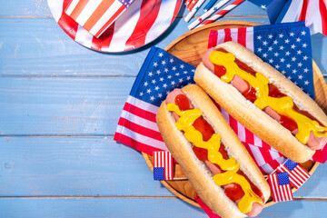 USA Patriotic picnic holiday hot dogs.  American patriotic hot dog on wooden board plate, with USA...