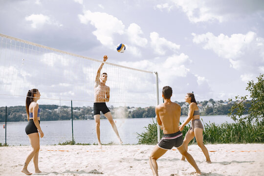 Young people playing volleyball on the beach
