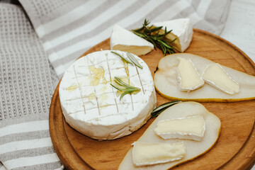 White baguette cut into pieces with olive oil and Camembert cheese on the table.