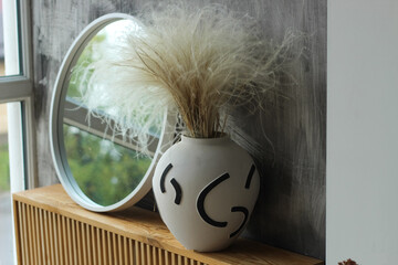 Fototapeta premium A modern vase with a mirror in a cozy interior.