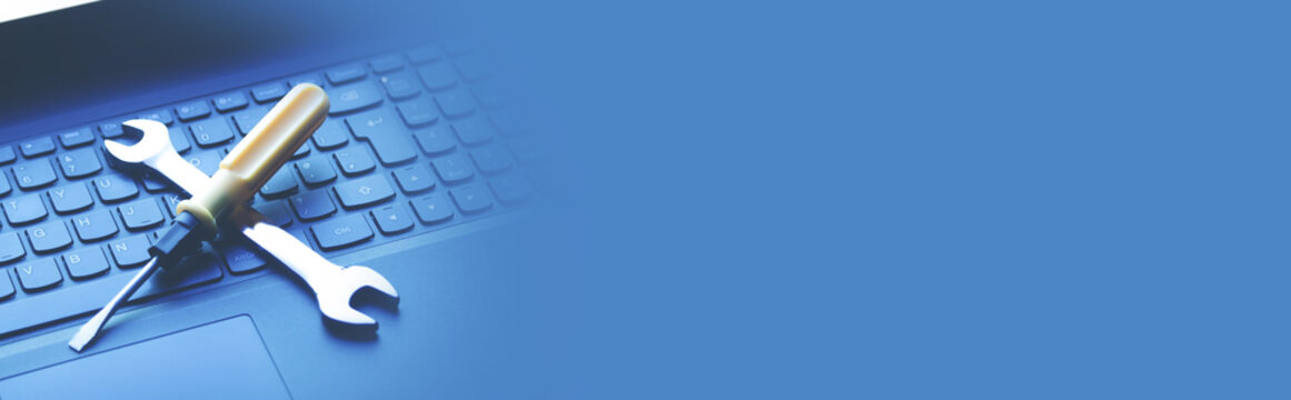 Wrench and screwdriver on the computer keyboard. IT Service. Support