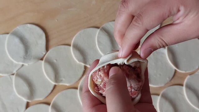 Traditional Buryad Buuz making process. Steamed dumpling filled with meat	
