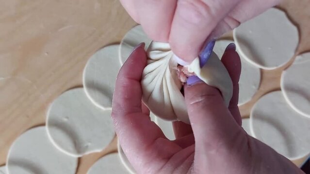 Traditional Buryad Buuz making process. Steamed dumpling filled with meat	
