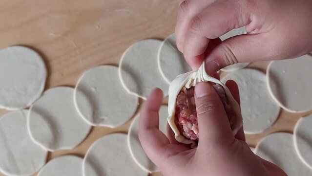 Traditional Buryad Buuz making process. Steamed dumpling filled with meat	
