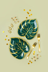Party paper plates in the shape of a tropical leaves and decorations for themed party. Set of holiday disposable tableware for party or picnic.
