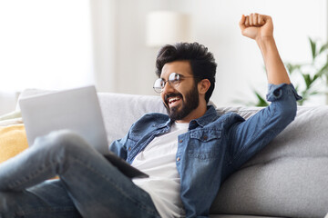 Online Win. Overjoyed Young Indian Man Celebrating Success With Laptop At Home Generative AI