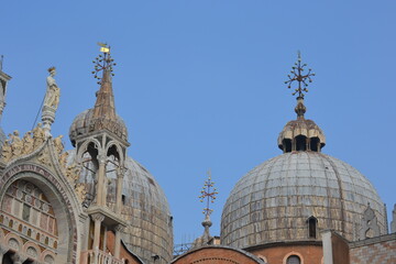 Fototapeta na wymiar Dome of a church in Venice with rich decoration and crosses on the domes