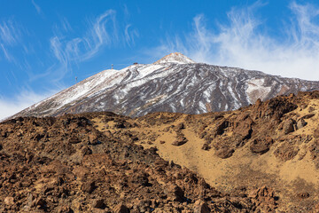 Snow-dusted Teide mountain over brown lava, Canary island of Tenerife, Spain
