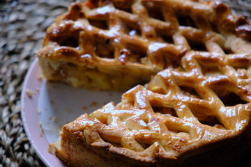 shot of sliced apple pie on wicker background
