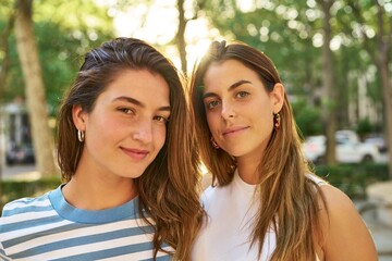Two friends smiling happily in a park.