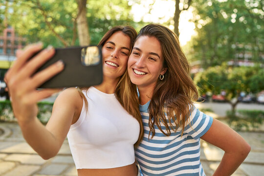 Smiling friends taking a selfie in the park.