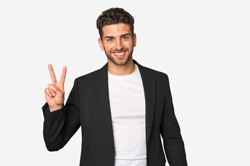 Young business man joyful and carefree showing a peace symbol with fingers.