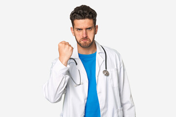 Fototapeta premium Young doctor man showing fist to camera, aggressive facial expression.