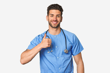 Young nurse man smiling and raising thumb up