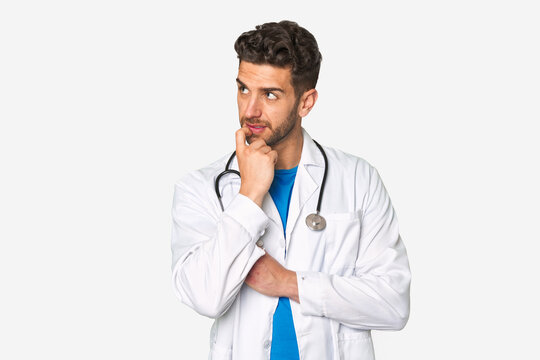 Young doctor man relaxed thinking about something looking at a copy space.