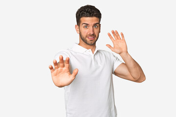 Young handsome man isolated being shocked due to an imminent danger