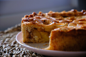 shot of sliced apple pie on wicker background