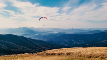 Looking down on a paraglider going down the mountain