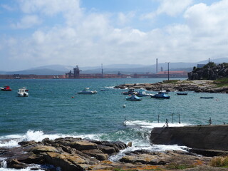pequeño puerto pesquero de la villa de Morás con sus  barcos y botes sobre las aguas azules del...