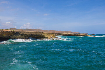 Fototapeta na wymiar Beautiful view of rocky coast washed by Atlantic Ocean waves. Aruba. 