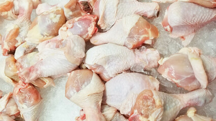 Fresh chicken thighs kept on ice cubes